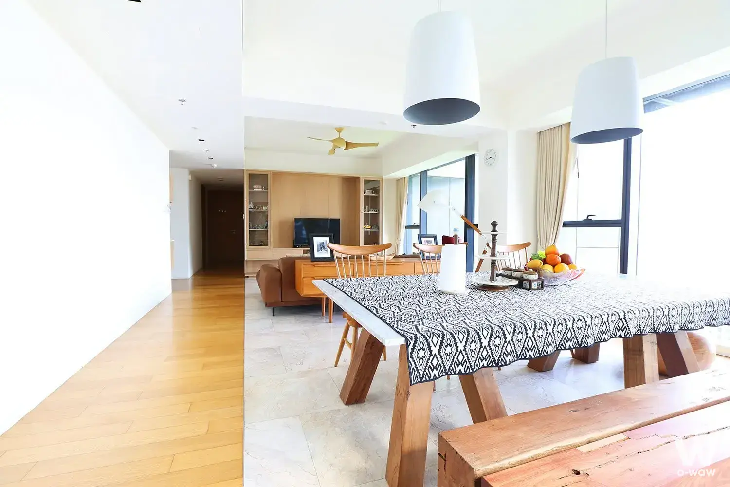 Open-plan dining and living room in a 3-bed condo for rent at The Met, with a wooden table and floor-to-ceiling windows