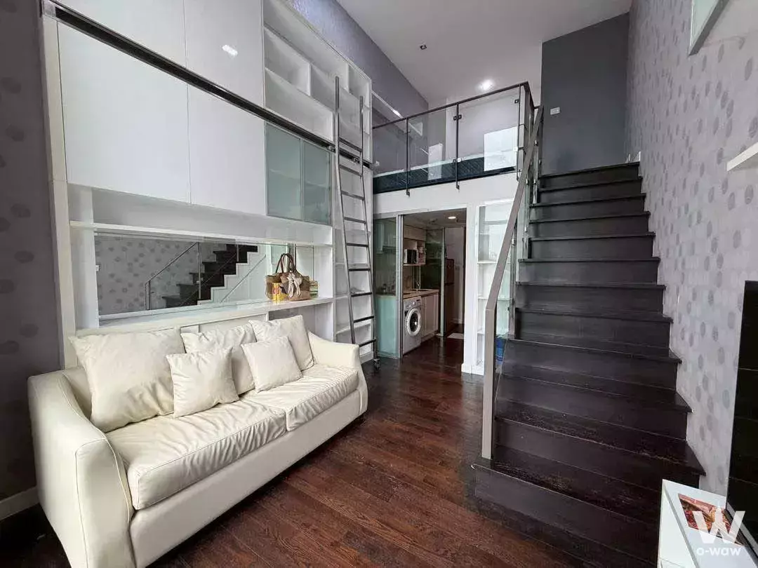 Duplex living area in Ideo Morph 38 with cream sofa, dark wood floors, and loft access