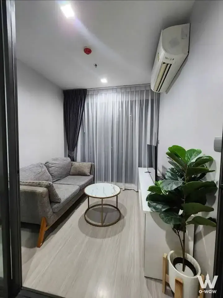 Grey sofa and marble coffee table in a tidy 1-bed condo for rent at Life Ladprao