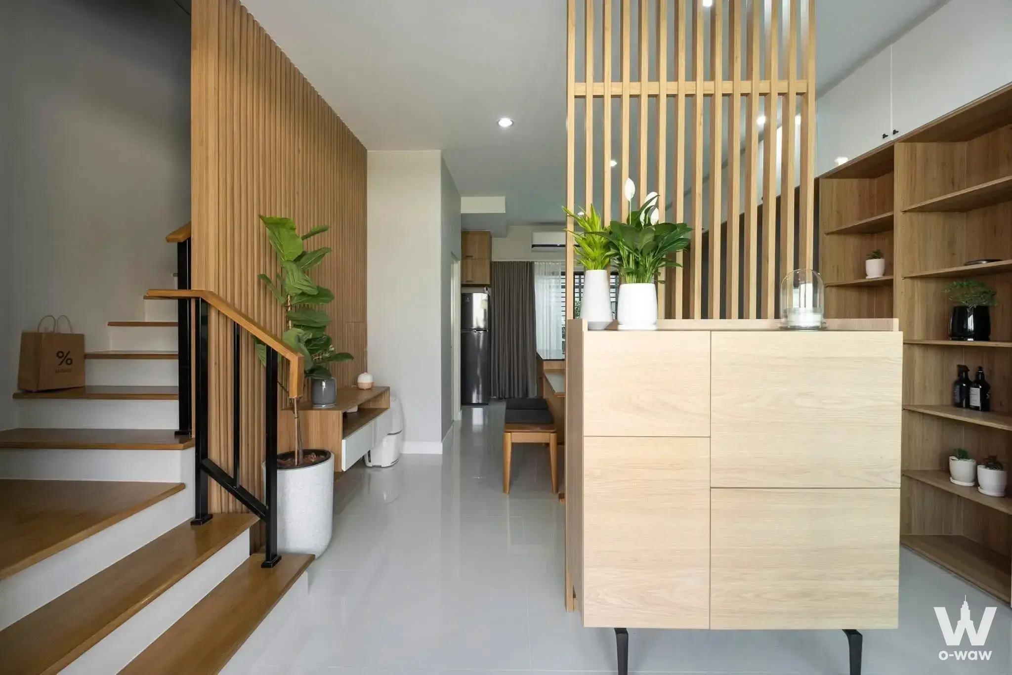Baan Klang Muang Rama 9 entryway with floating staircase, wood slat walls, and Scandinavian style