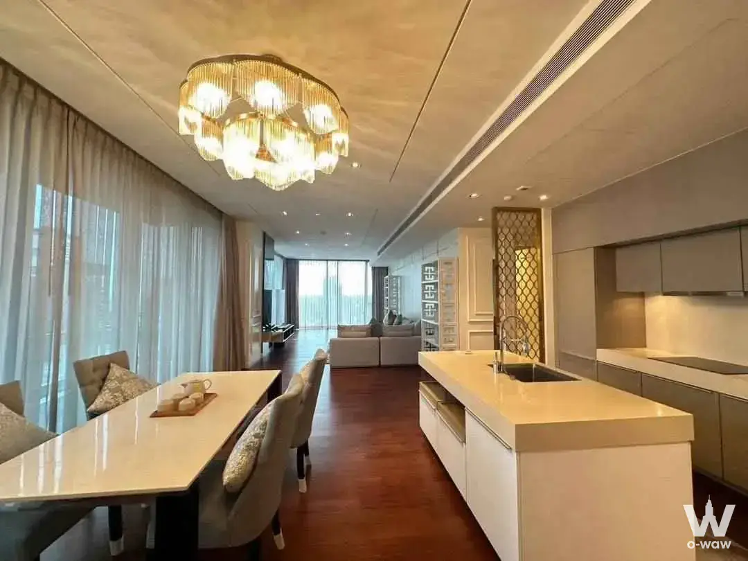 Spacious open-plan living area with marble dining table, crystal chandelier, and city view