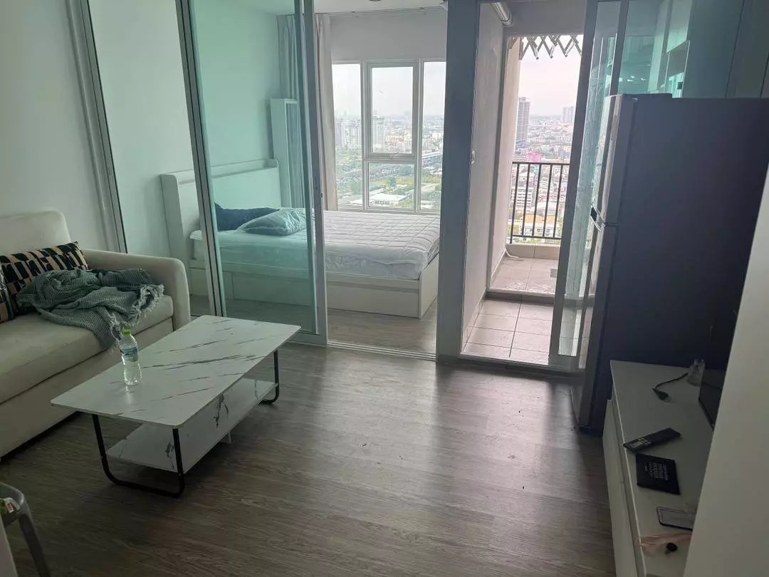 Open-plan studio with glass partition, white sofa, and city views in Regent Home Bangna 1-bed condo