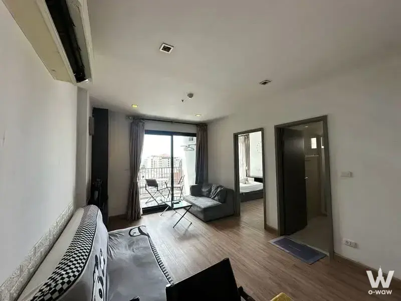 Compact studio living area with sofa, panda-themed bed, and balcony view at The Base Central Pattaya