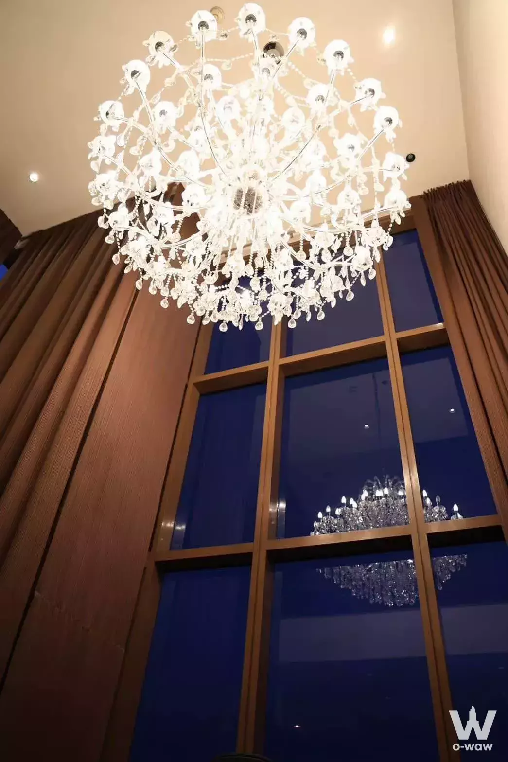 Luxury lobby of 1-bed condo for rent in The Emporio Place featuring crystal chandelier and floor-to-ceiling windows