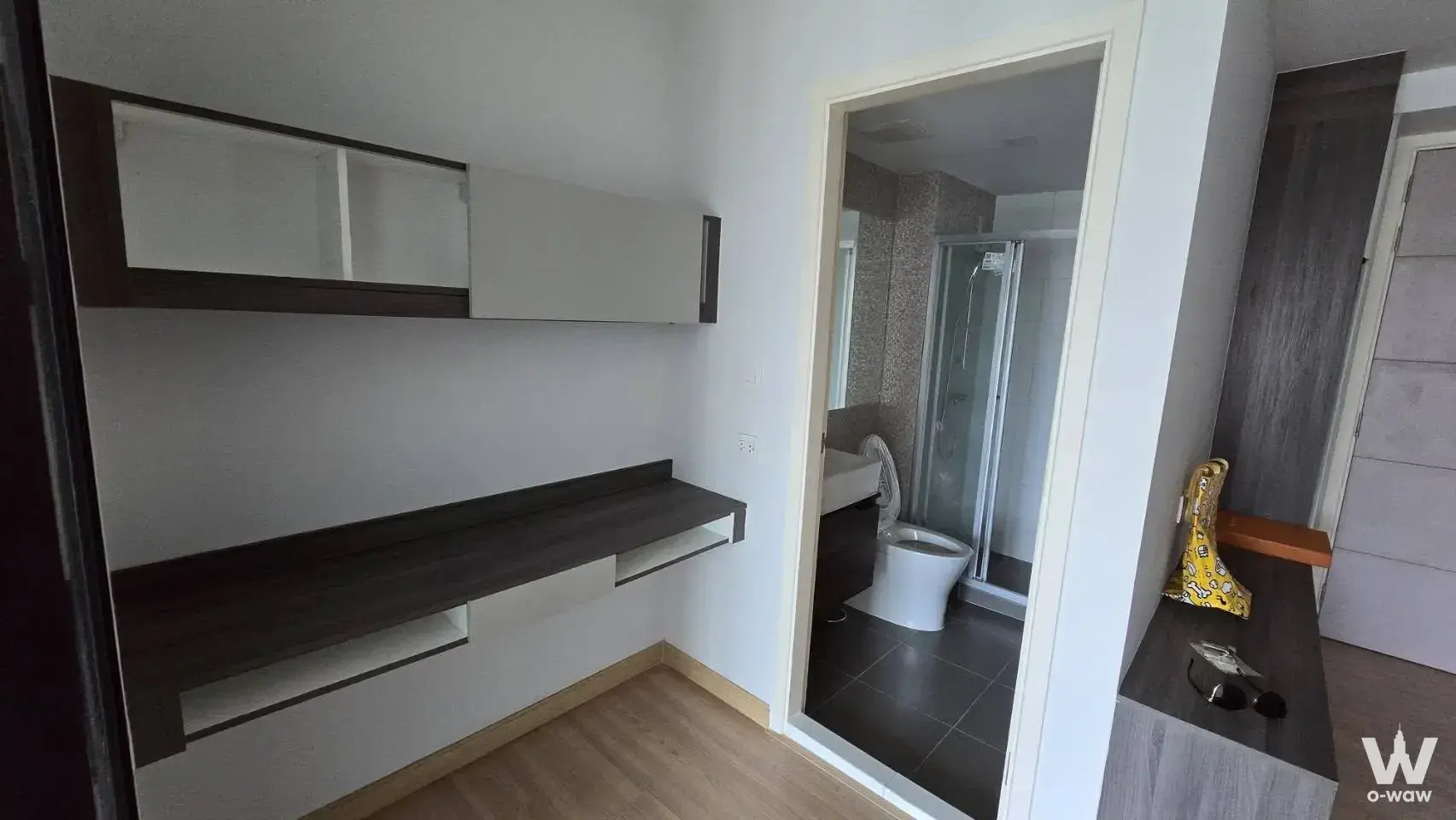 1-bed condo entryway with floating desk unit and hallway leading to bathroom in Knightsbridge Skycity