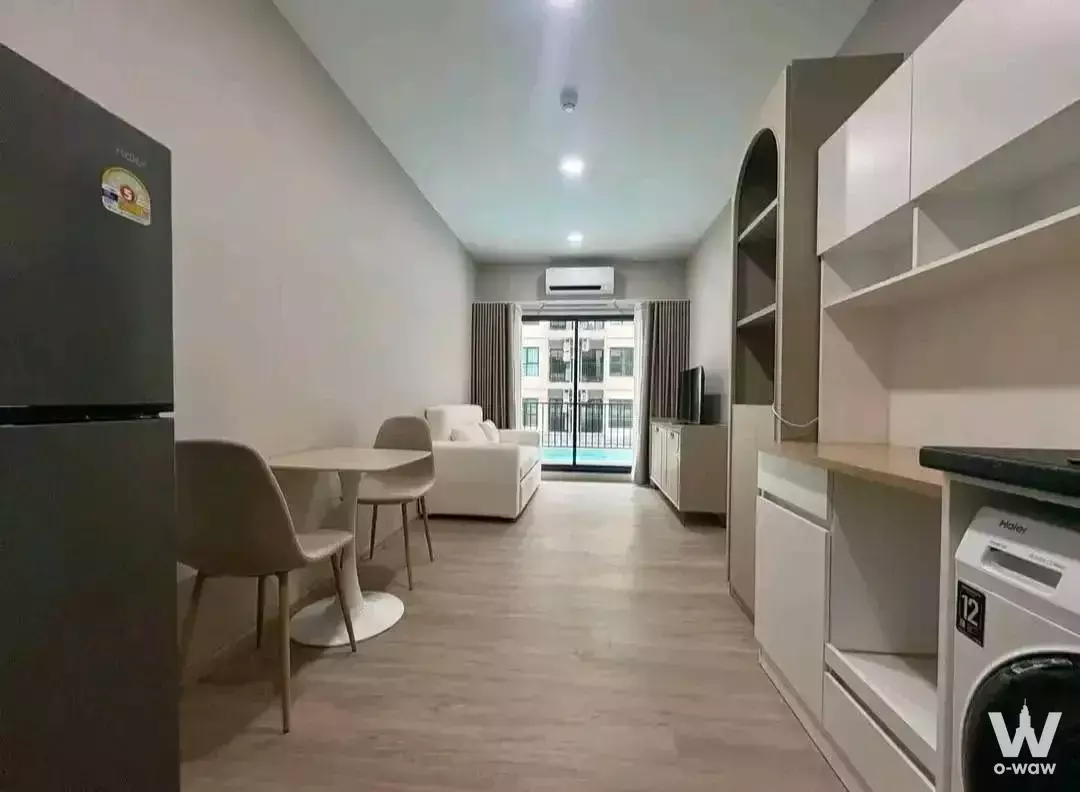 Supalai Sense Srinakarin studio with dining area, sofa, and floor-to-ceiling cabinetry