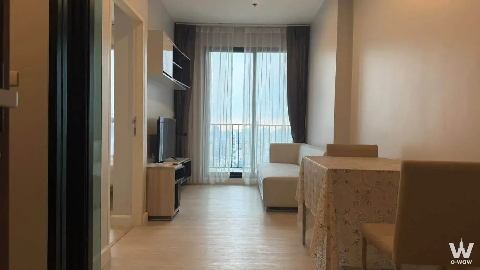 Open-plan living and dining area with city skyline view in Nich Pride Thonglor