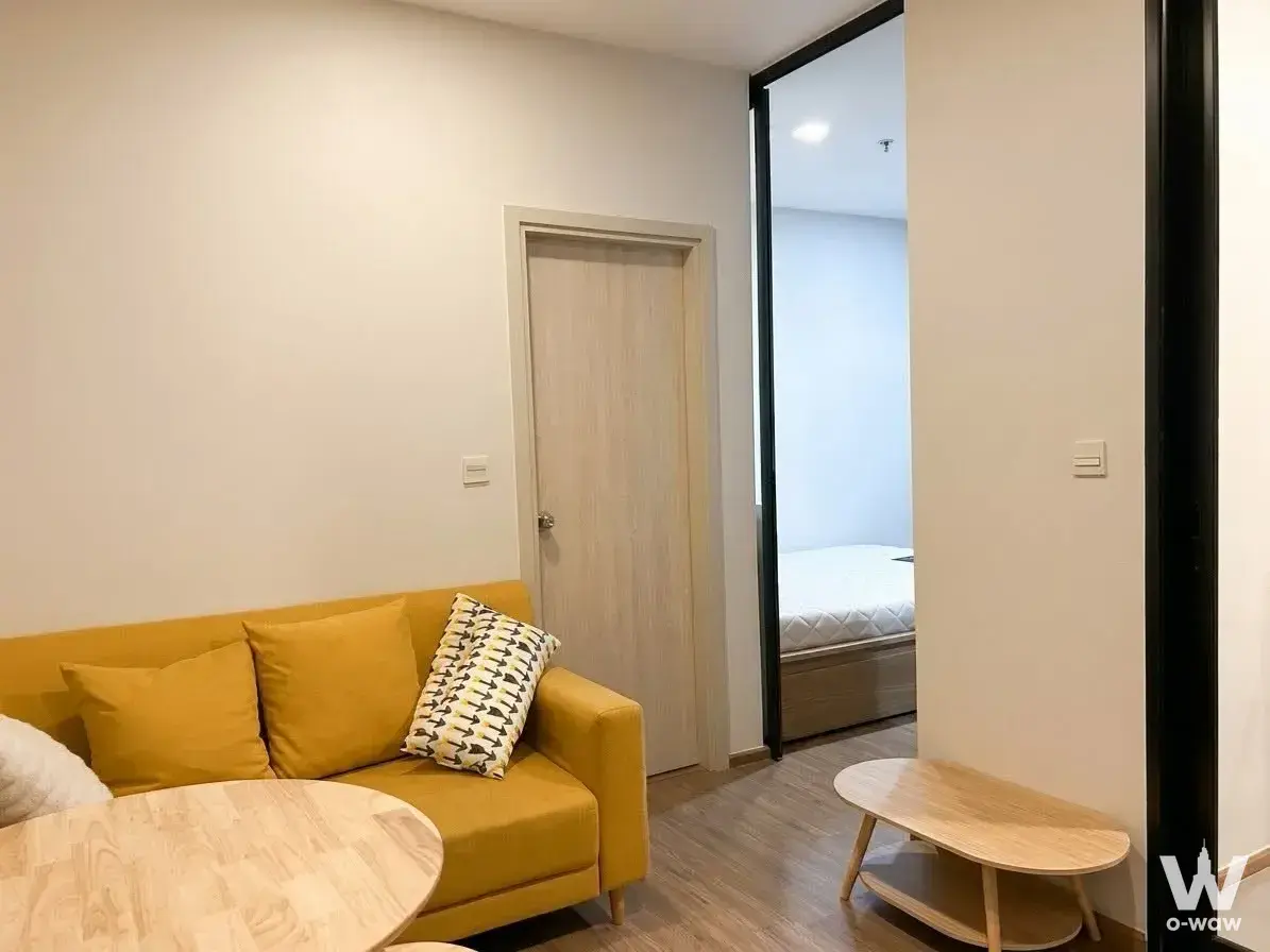 Yellow sofa and coffee table in a Metris Rama 9-Ramkumhang 1-bed condo for rent