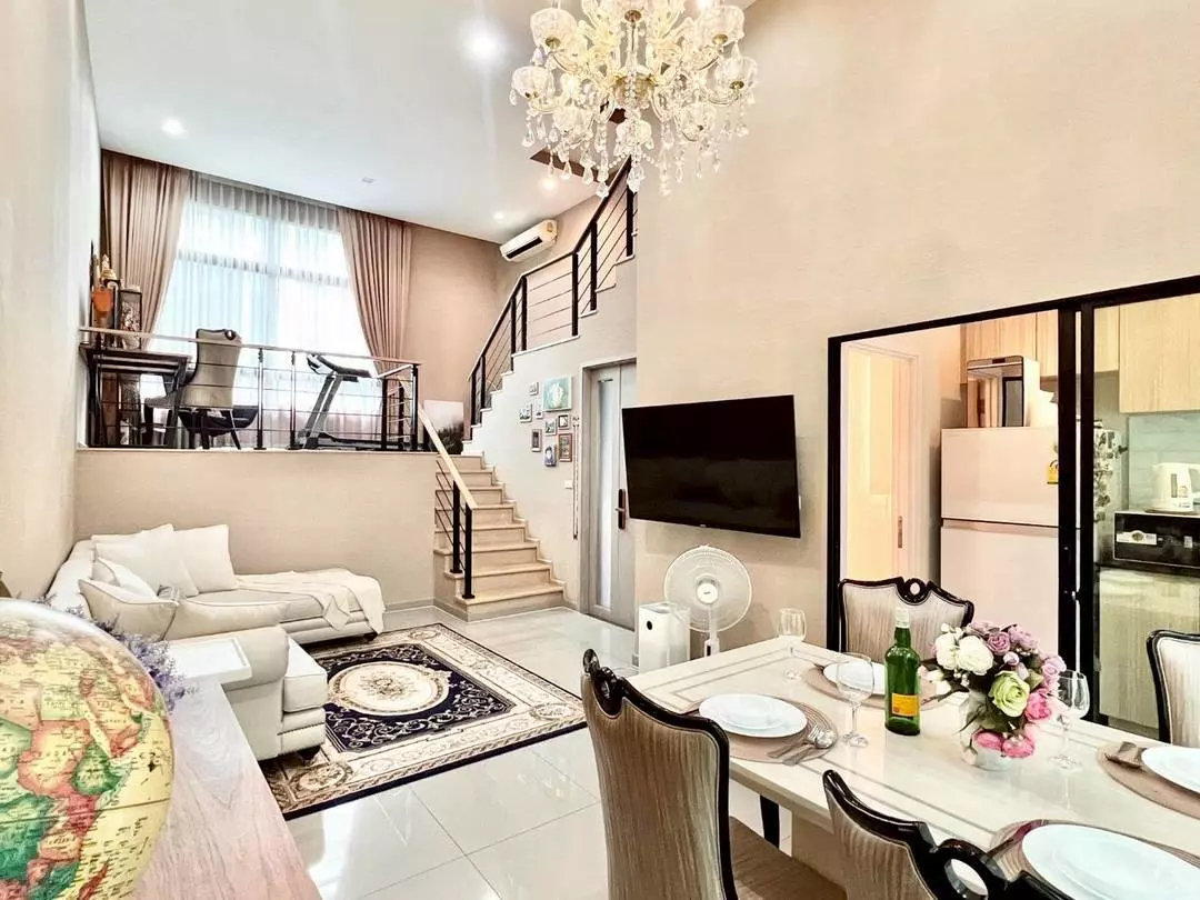 Spacious living room in 3-bed condo for sale at Arden House featuring chandelier, sectional sofa, and mezzanine gym