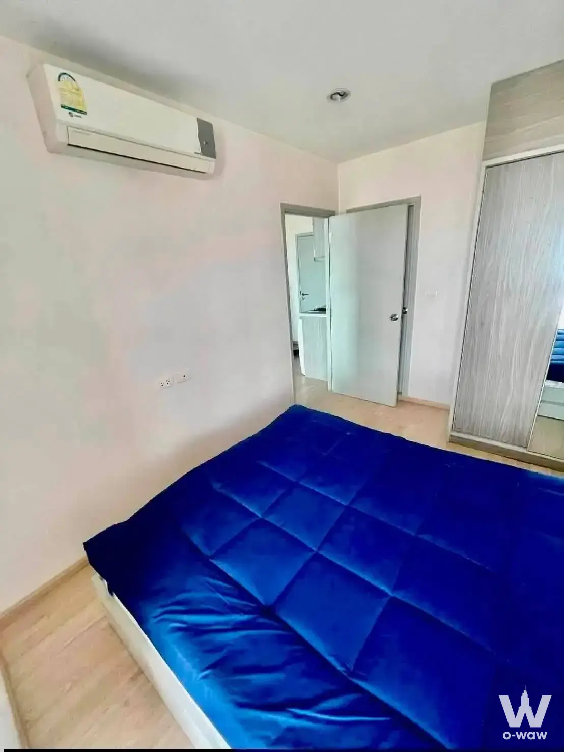 Minimalist bedroom in ASPIRE Sathorn-Ratchapruk showing a queen bed and mirrored sliding wardrobe doors