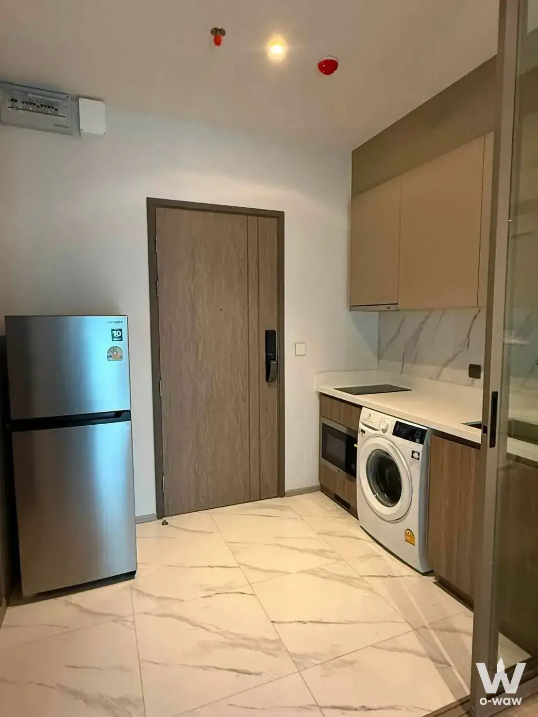 Kitchenette in a Rhythm Ekkamai condo with quartz counter and smart lock entry
