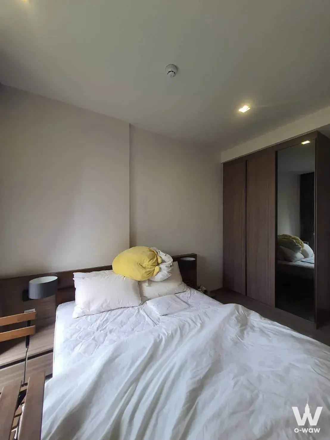Master bedroom with dark wood wardrobe in a 1-bed condo for sale at Mori HAUS