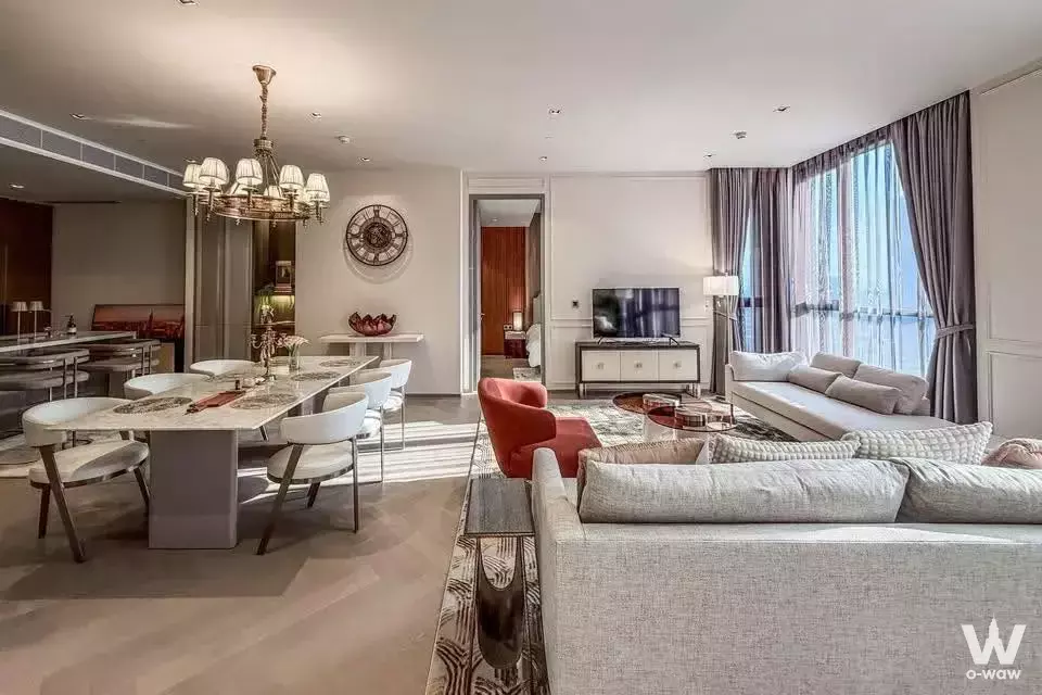 Spacious living room in The Reserve Sathorn 2-bed condo featuring grey sofas and marble dining table