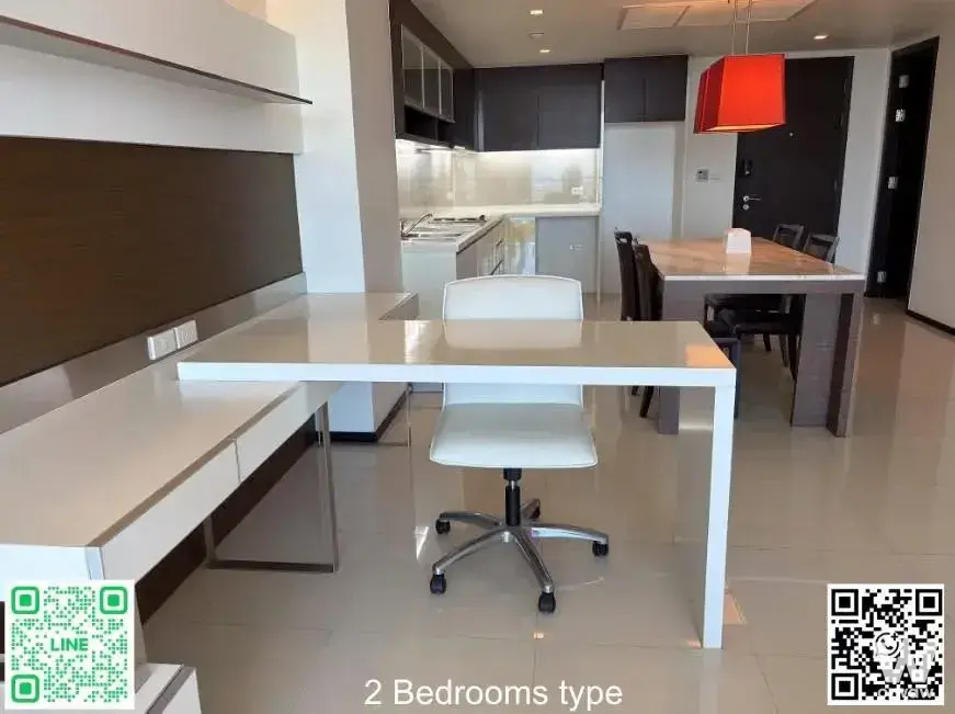 Sathorn Prime Residence open plan living area with white L-desk, dining table, and red pendant lamp