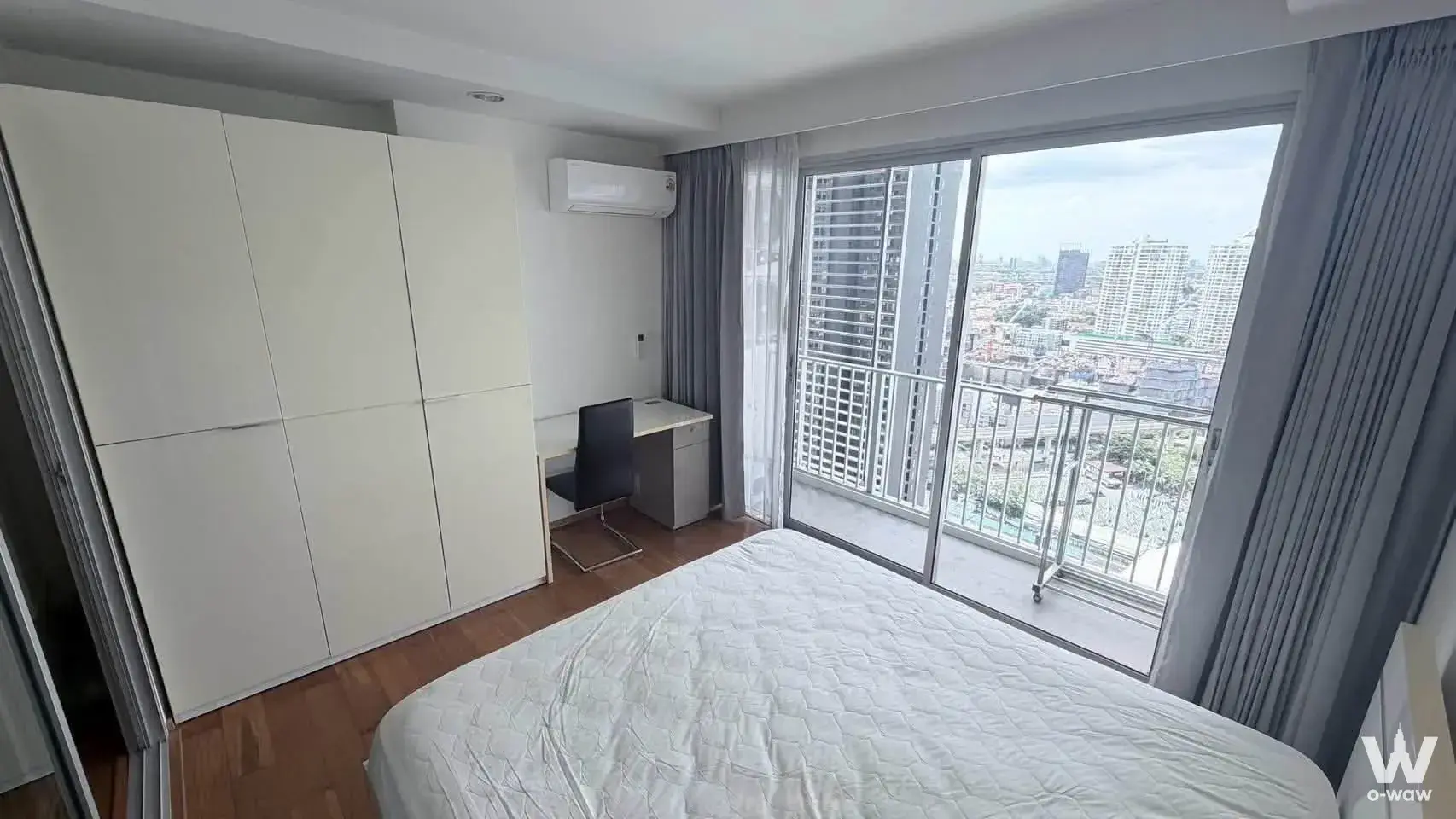 Bedroom in The Park Condominium with floor-to-ceiling wardrobe, balcony access, and city skyline view from high floor