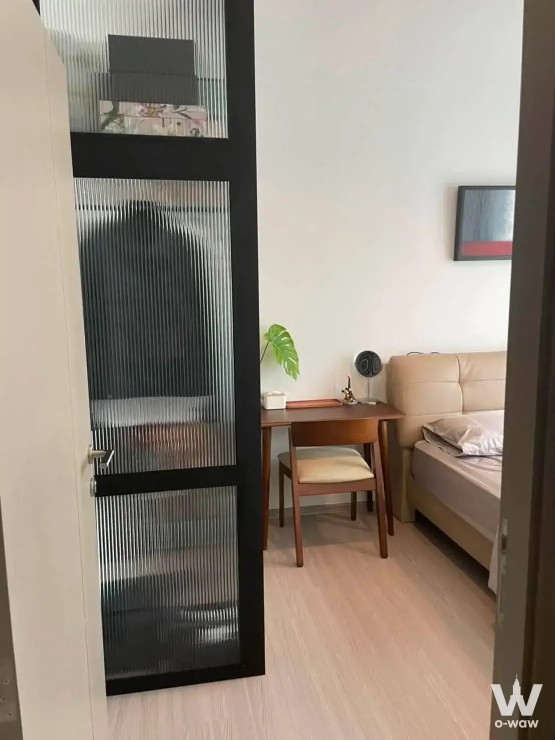 Bedroom in a Life Asoke Hype rental with fluted glass partition, beige leather bed, and minimalist wooden desk