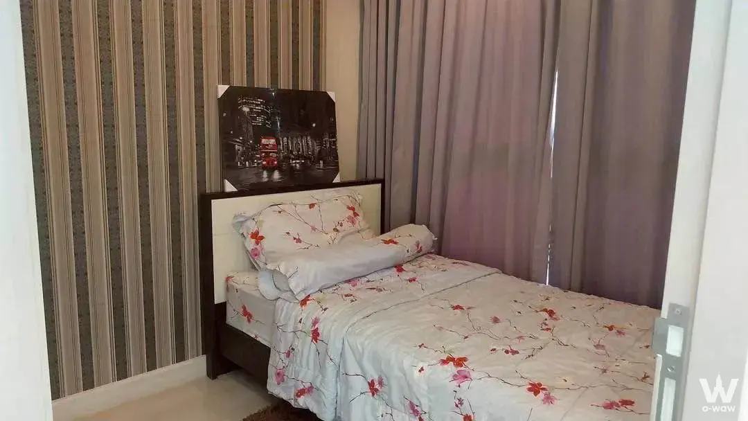 Compact bedroom in Ideo Mobi Sukhumvit 81 rental with striped wallpaper and floral bedding