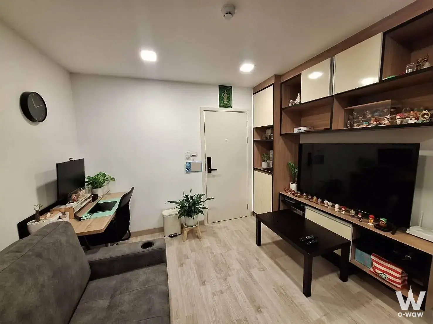 Living room in The 1 Plus Grand Ramkhamhaeng for sale with grey sofa desk setup and built-in wall unit
