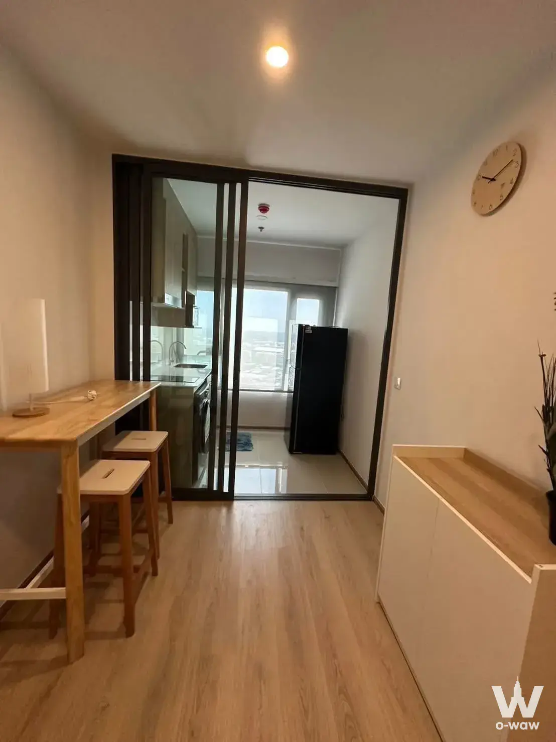 Life Rama 4 - Asoke open-plan dining area with glass partition, light wood flooring, and kitchen access