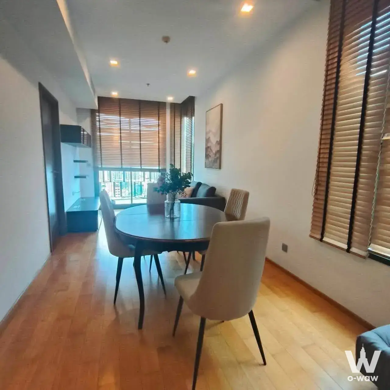 Dining area in a 2-bed Keyne by Sansiri condo featuring an oval wood table and city views