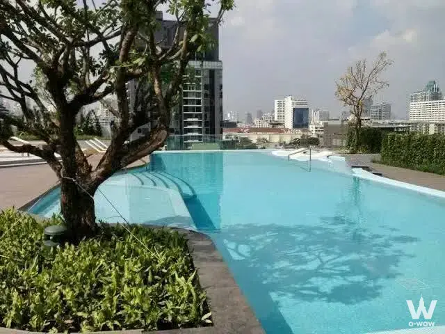 Rooftop infinity pool at CEIL By Sansiri overlooking the Bangkok skyline with glass railings