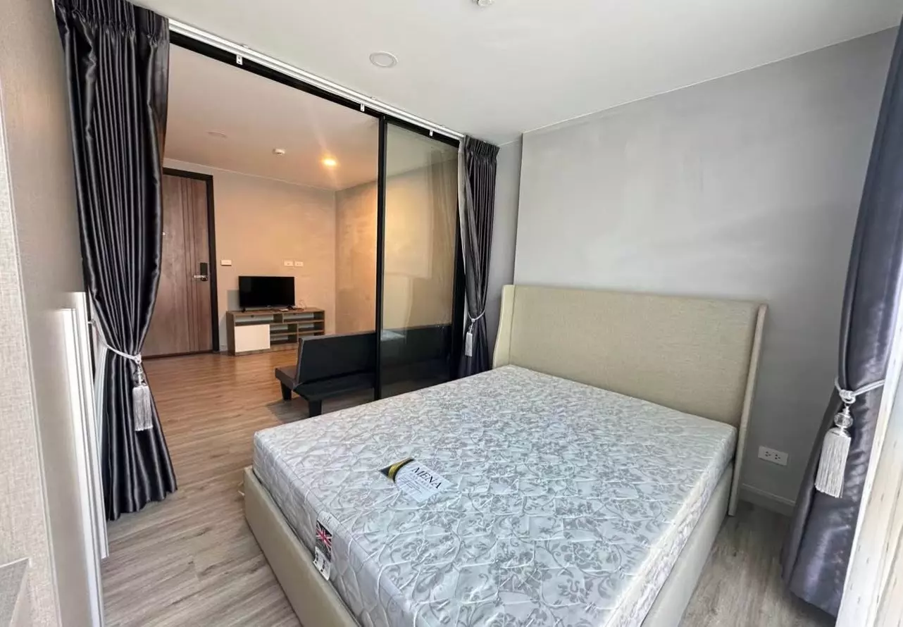 Bedroom in The Belgravia Condo Ratchada Ladprao15 with new mattress, glass partition, and view into living area