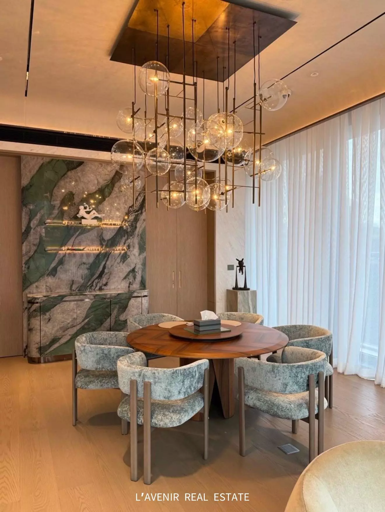 Dining room in SCOPE Langsuan 2-bed condo for sale with sage green chairs and marble feature wall