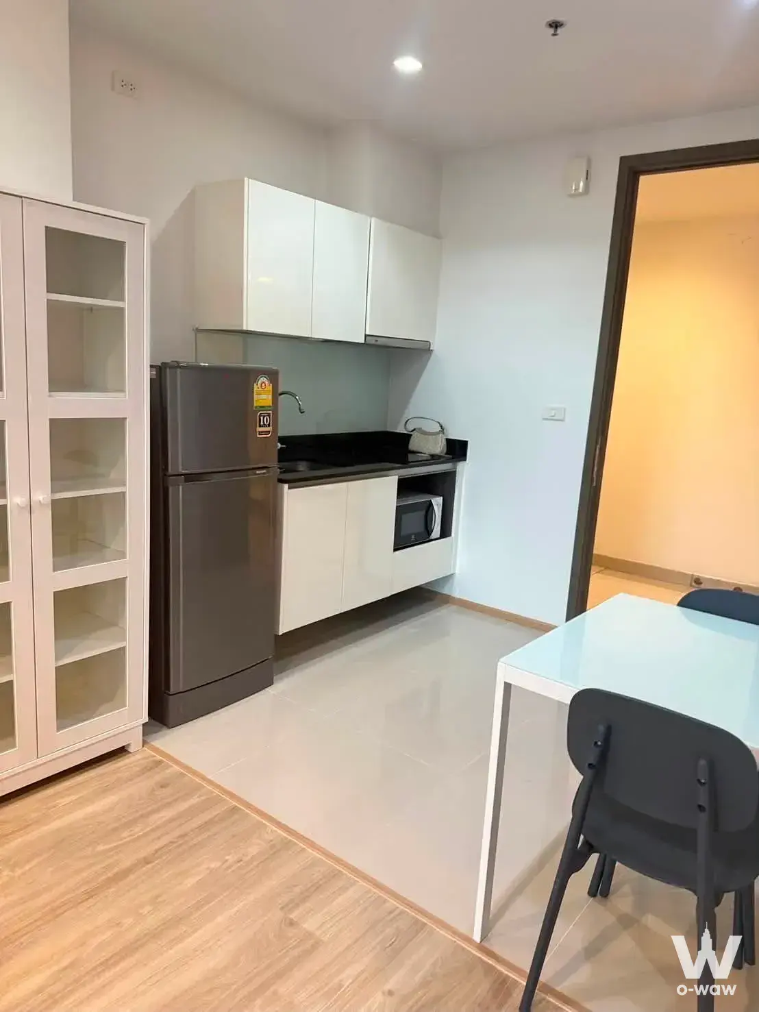 Kitchen in a 1-bed Quinn Condo rental with white cabinets, black granite counters, and a dining table