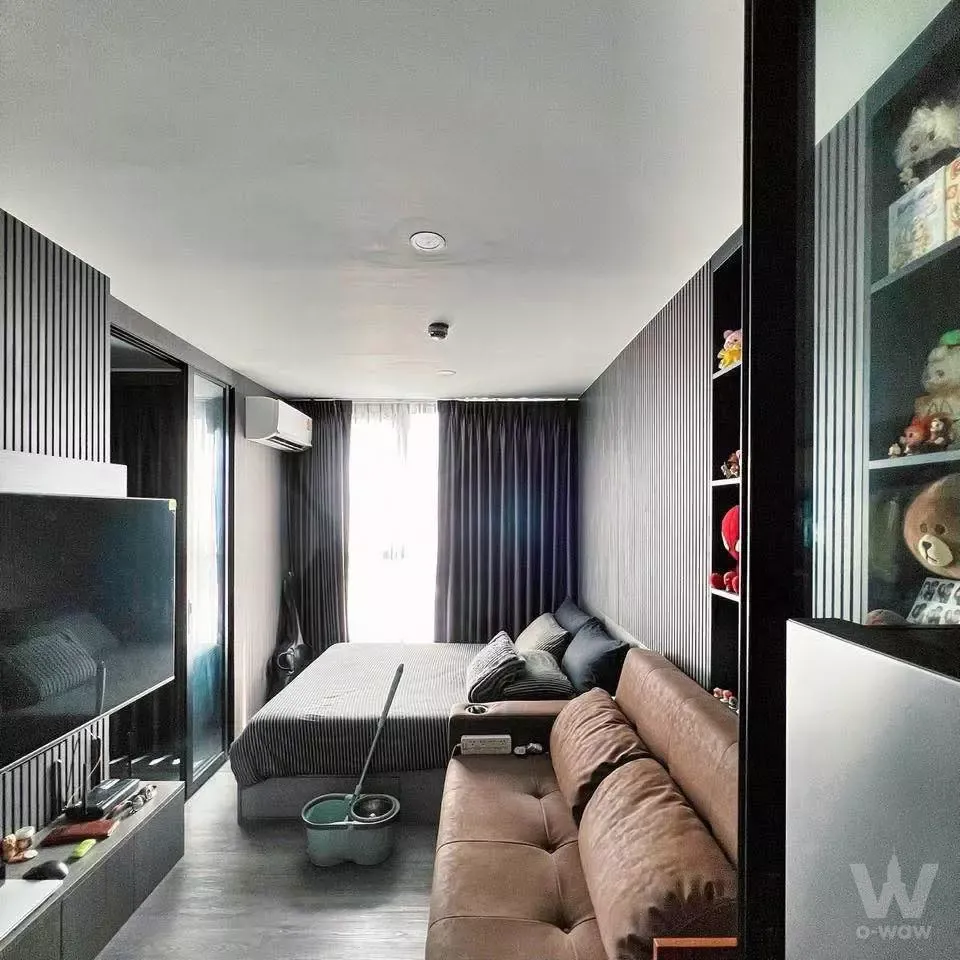 1-bed condo for sale in The Origin E22 Station featuring dark grey floors, black slat wall, and queen bed