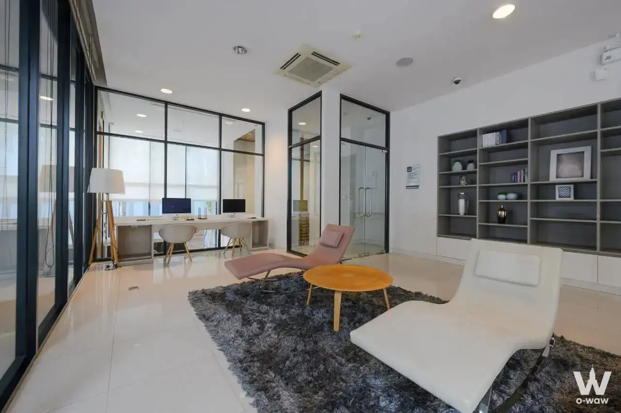 Modern office lounge with pink chaise and shared desk in this LIV@49 workspace