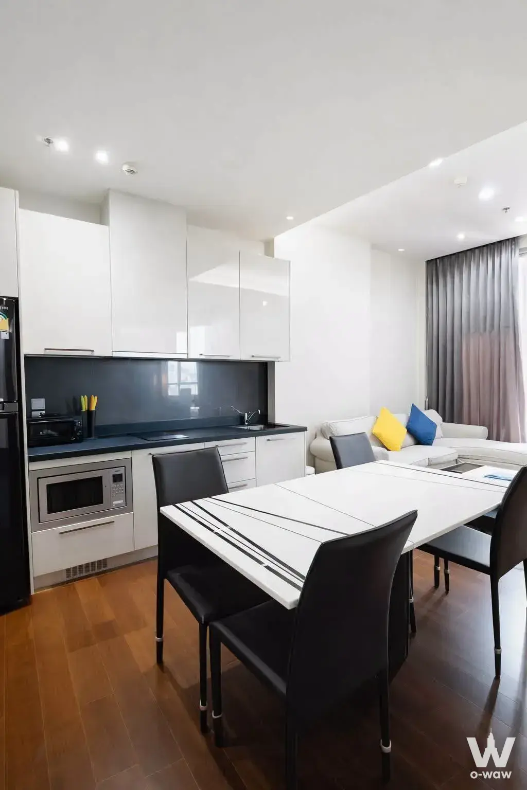 Open-plan 1-bed condo in Quattro by Sansiri with white kitchenette, dining set, and L-shaped sofa