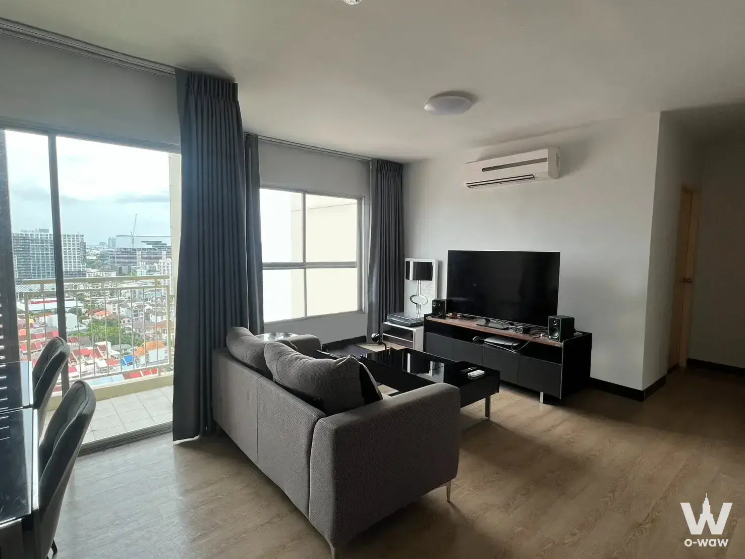 S&S Sukhumvit 2-bed condo living room with grey sofa, city view, and modern furnishings