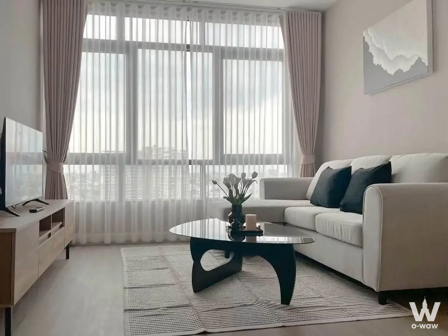 Living room with sofa and city view in 2-bed condo for sale in Metro Sky Prachachuen