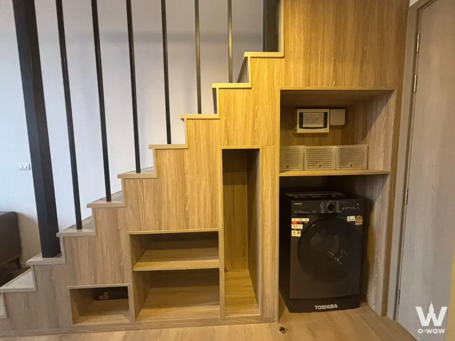 Oak staircase with storage cubbies and washer niche in this Siamese Sukhumvit 87 condo