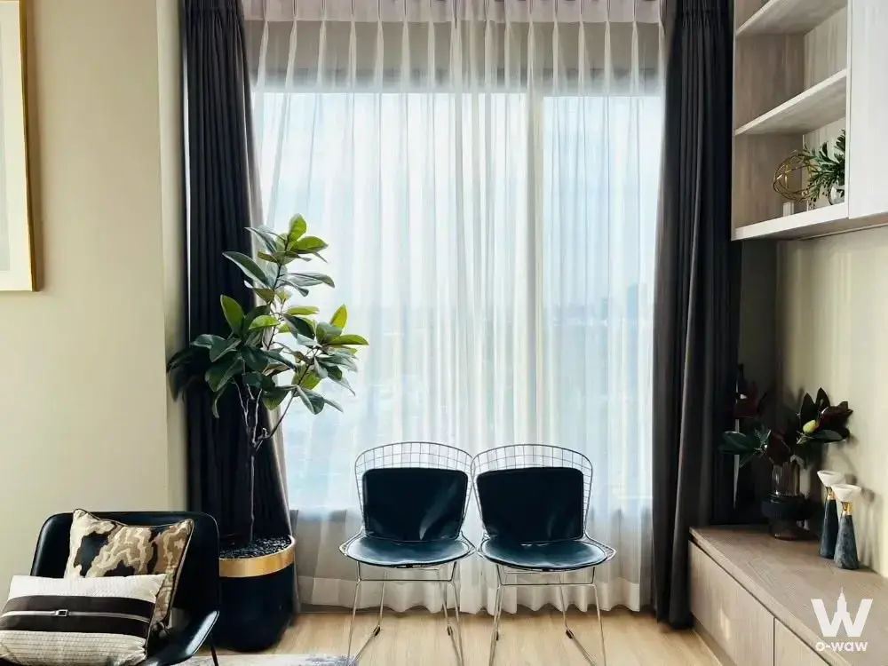 M Jatujak 0-bed condo living room featuring floor-to-ceiling windows and black wire chairs
