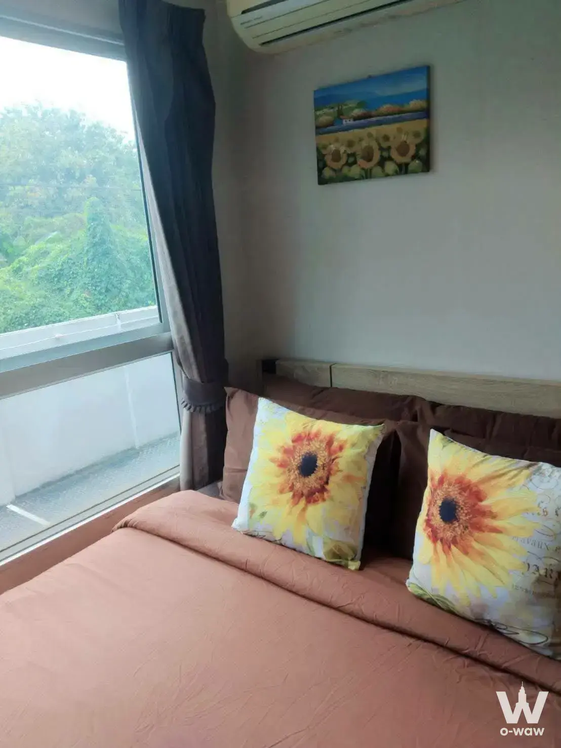 Bedroom with sunflower pillows and garden view in Metro Luxe Phaholyothin-Suthisan condo