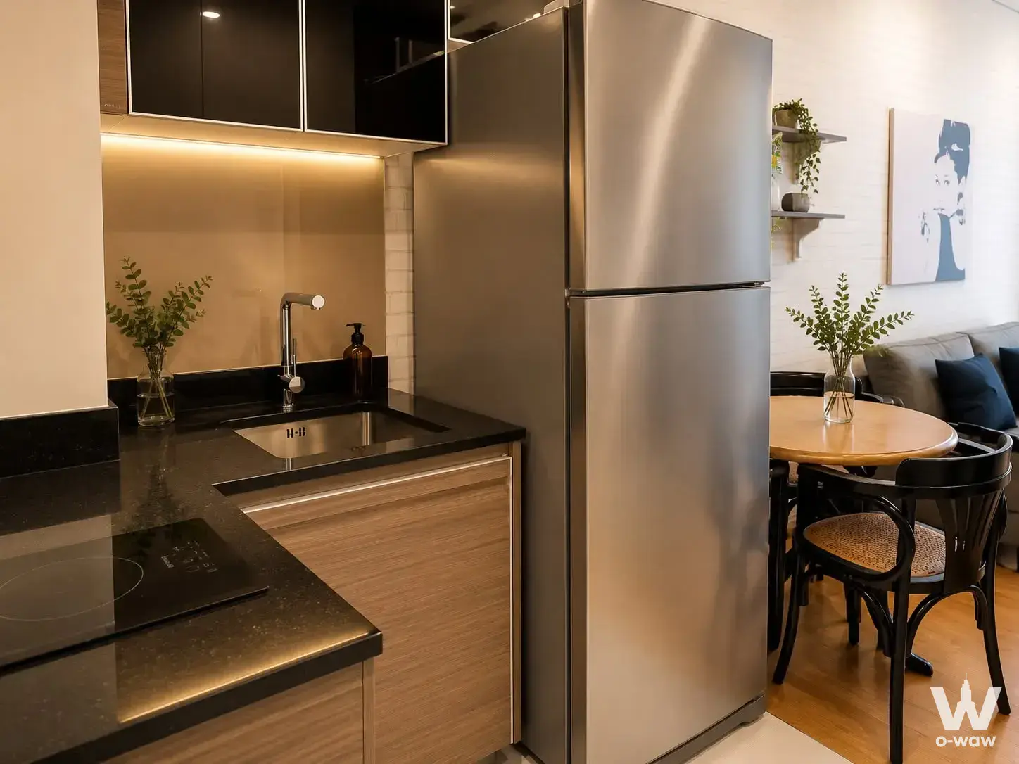Kitchen-dining area in a Keyne by Sansiri 1-bed condo with black granite counters and light wood cabinets