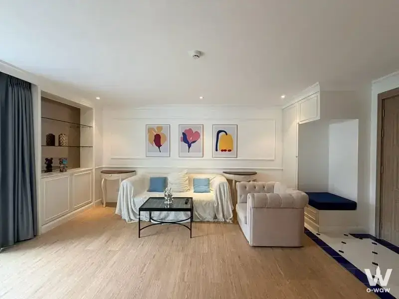 Bright living room in a 3-bed Seven Seas condo with oak floors and blue accent pillows