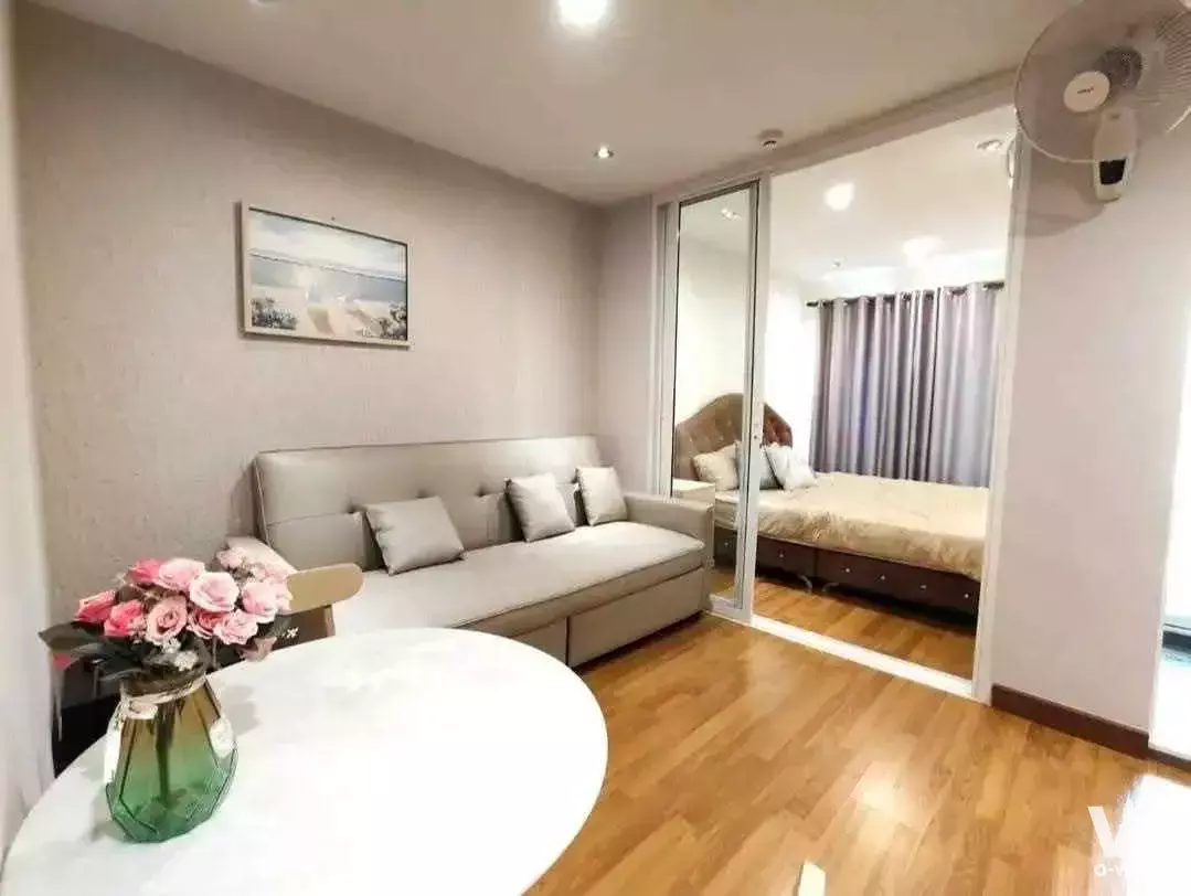 Glass-partitioned bedroom and beige sofa in 1-bed condo at Regent Home Sukhumvit 81