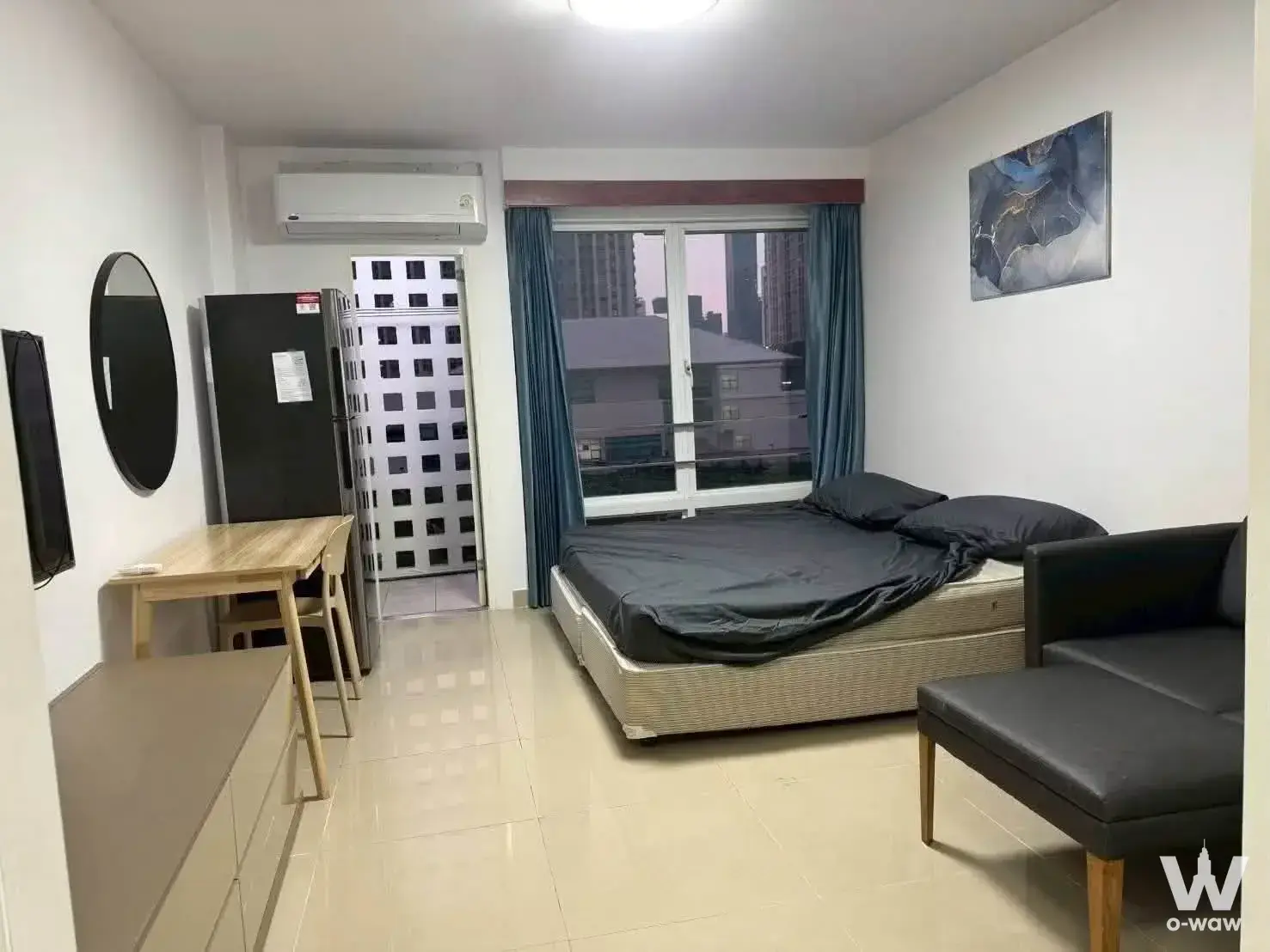 Fully furnished 1-bed condo bedroom in Arden House with queen bed, black sofa, and teal curtains