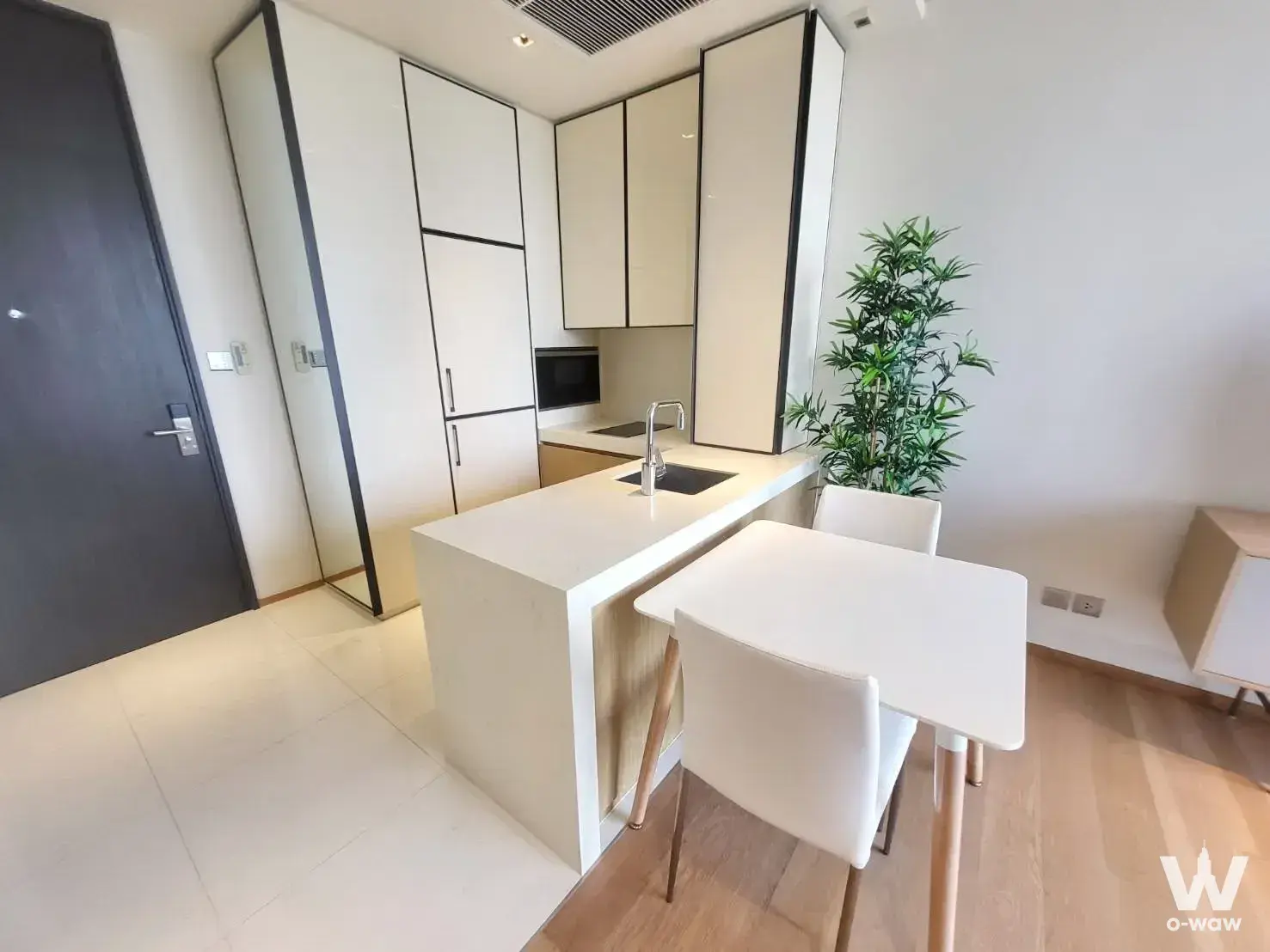 Modern kitchen with white quartz island and dining nook in a BEATNIQ condo