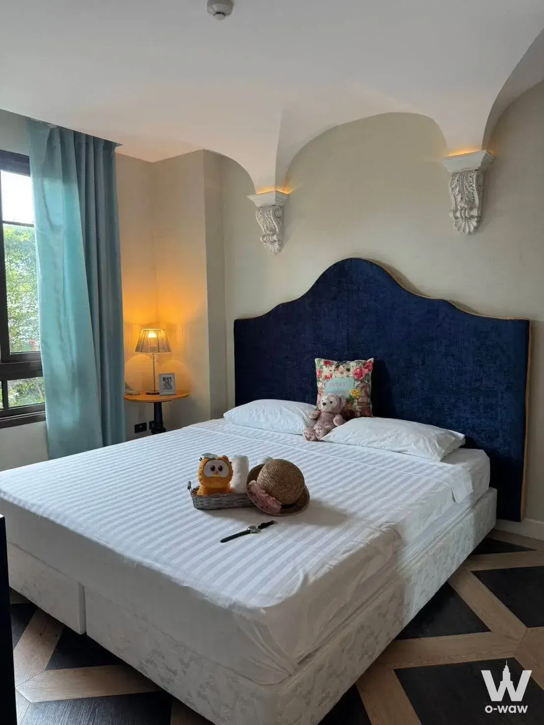 Bedroom with navy upholstered headboard and teal curtains in Espana Condo Resort Pattaya 1-bed condo
