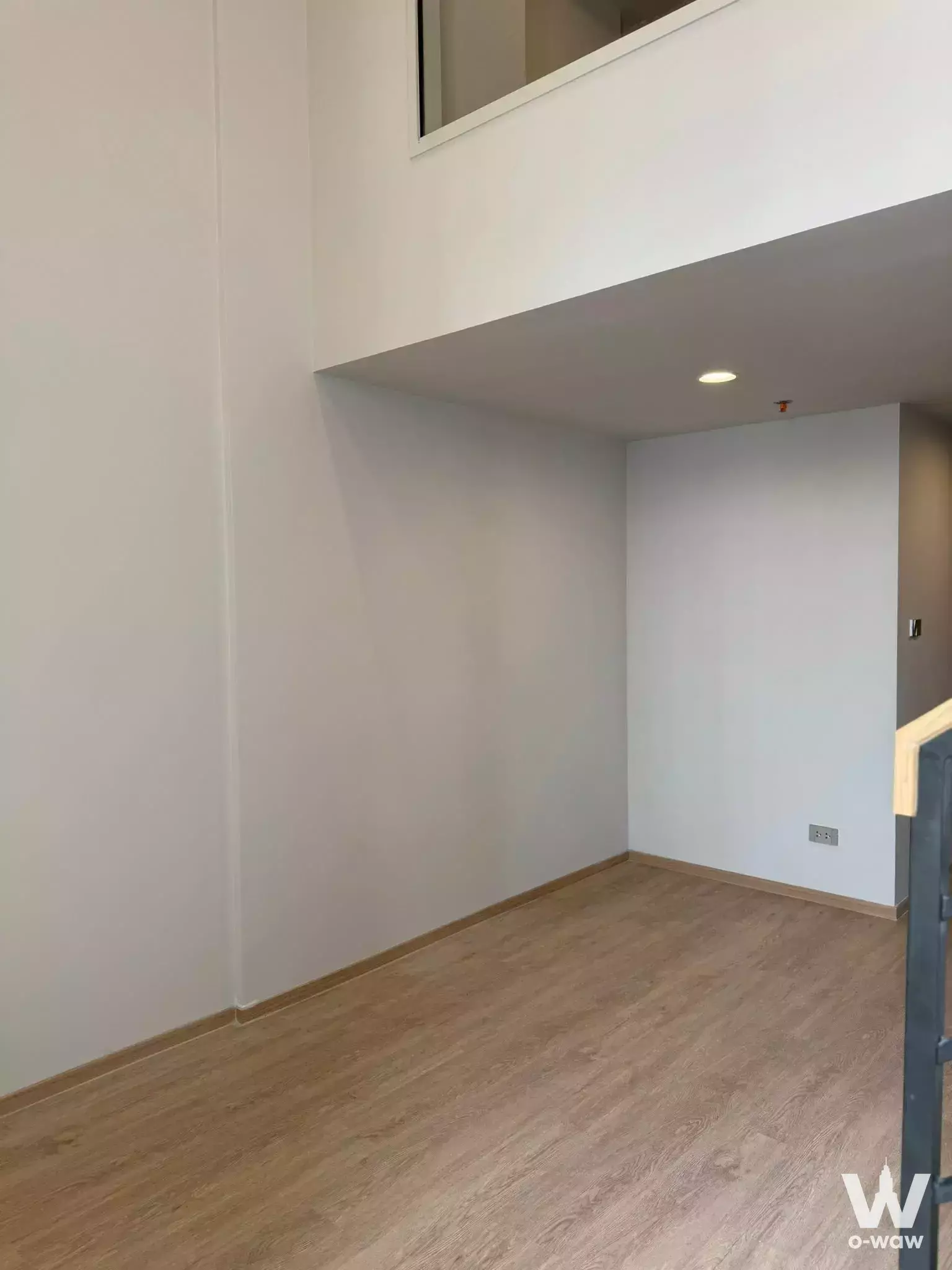 Empty loft-style room in Culture Chula duplex with high ceilings and mezzanine access