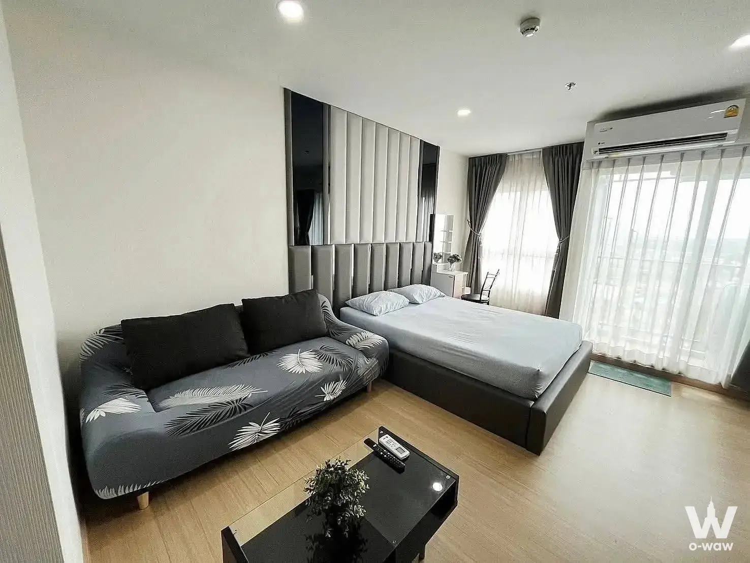 Furnished studio bedroom in a 1-bed condo at Supalai Veranda Sukhumvit 117 featuring a leather bed and sheer curtains