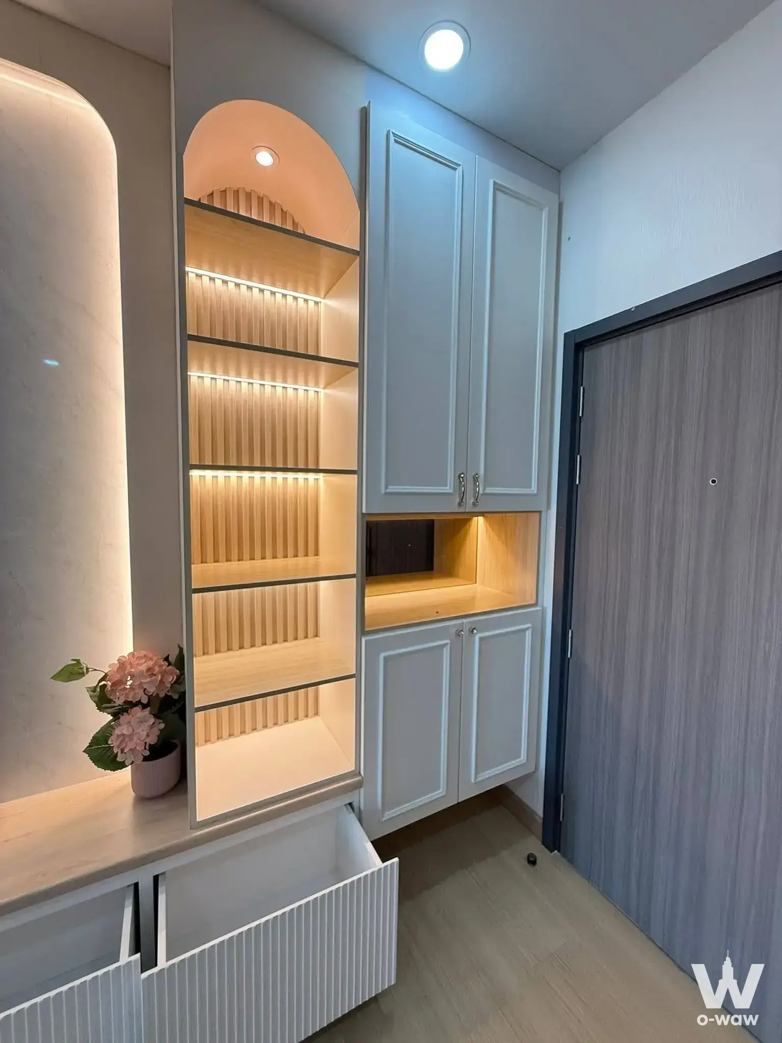 Entryway in Supalai Loft Prajadhipok condo with lit arched display niche, fluted drawers, and white cabinetry