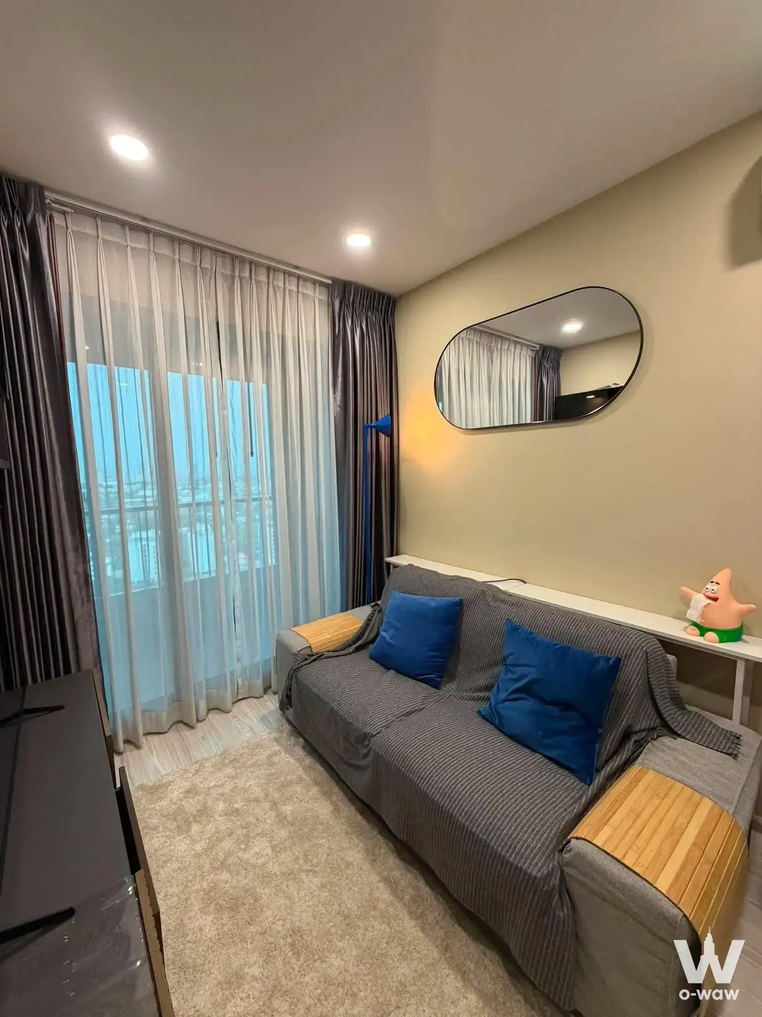 Grey sofa and blue accents define this tidy living space in Ideo Mobi Sukhumvit Eastgate