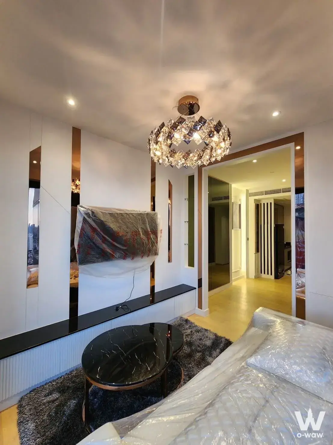 Living room with marble coffee table and bronze accents in a pristine 1-bed condo for rent at ASHTON Asoke