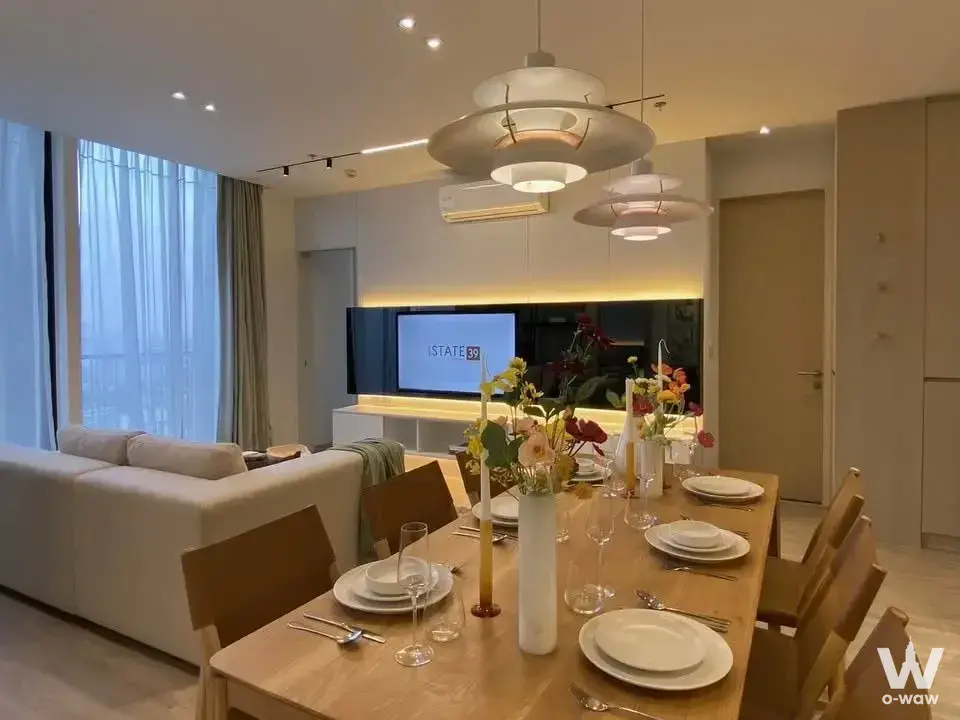 Open-plan living and dining in a 2-bed Noble State 39 condo featuring oak table and floor-to-ceiling windows