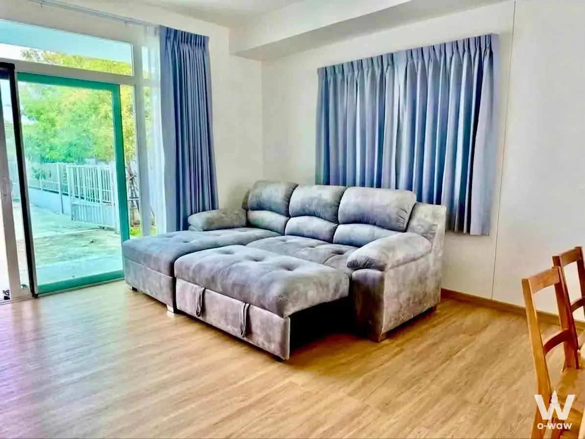Spacious living room in Q District house featuring grey sectional sofa and patio access