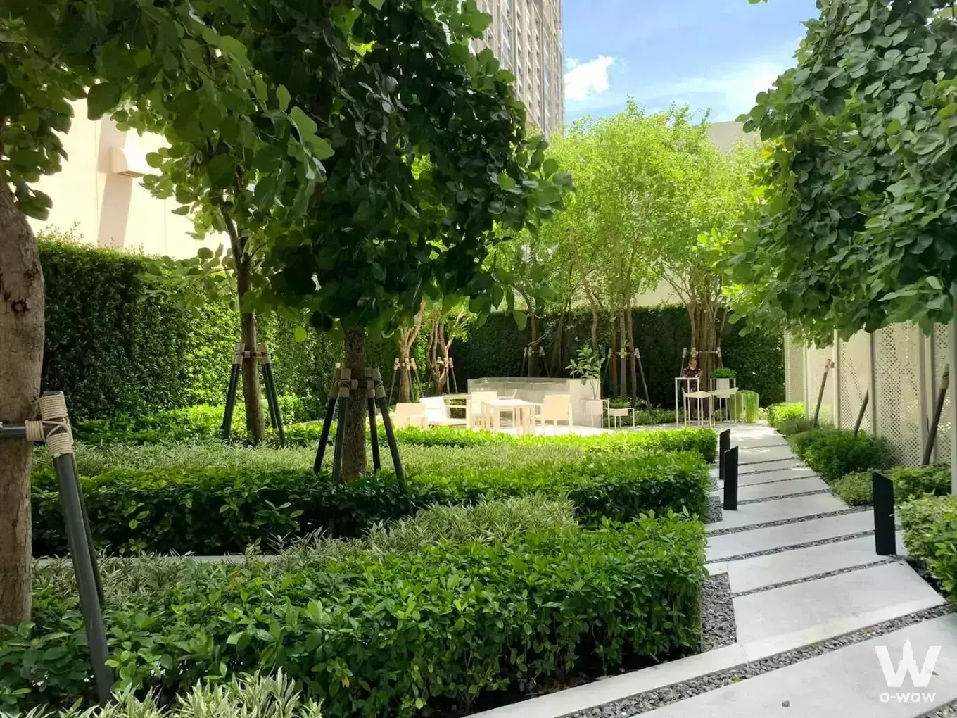 Landscaped garden with stone path and white seating at Life Ladprao 1-bed condo